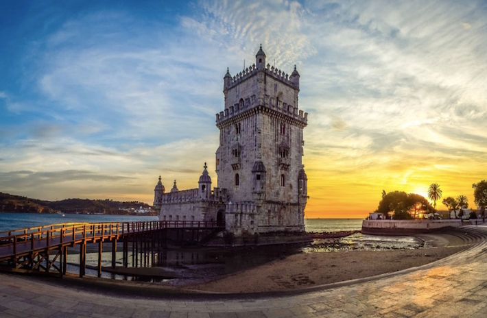 a large clock tower towering over the city of london with Belém Tower in the background