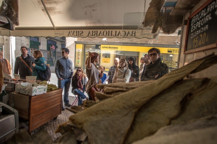 Group listening guide's explanation in a shop in Lisbon