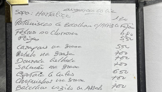Handwritten restaurant menu with dishes and prices in Portuguese.