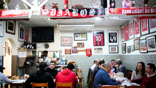 People dining in a sports-themed restaurant with jerseys and memorabilia on the walls.