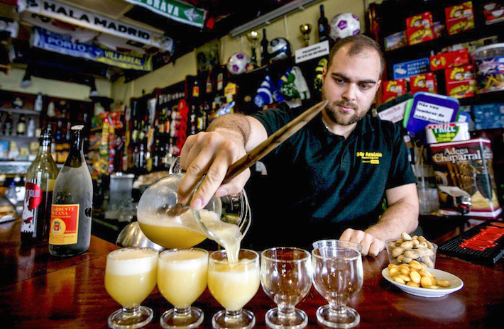 a person sitting at a table with food and drinks