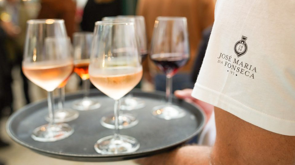 a close up of a person sitting at a table with wine glasses