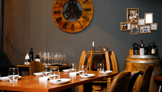 Cozy dining area with a wooden table, wine glasses, and wall decor.