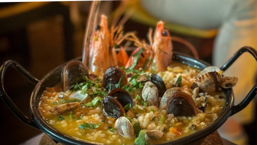 Seafood paella with shrimp, mussels, and clams in a pan.