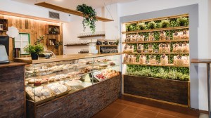 a room filled with furniture and vase of flowers on a kitchen counter