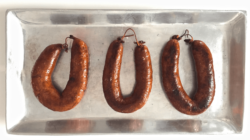 00.History of Alheira_feat photo a tray of hot dogs on a grill