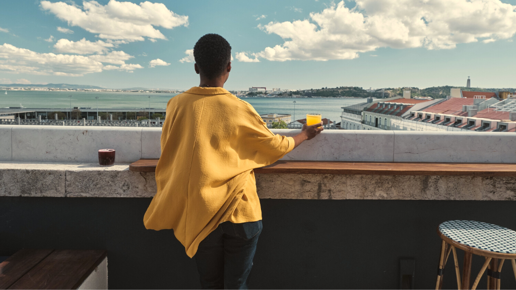 00.Best rooftop bars in Lisbon_feat photo a man standing in front of a beach