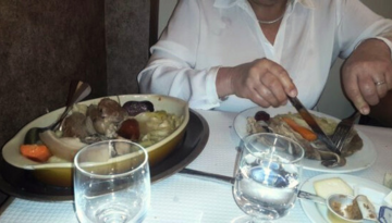 a person sitting at a table with a plate of food