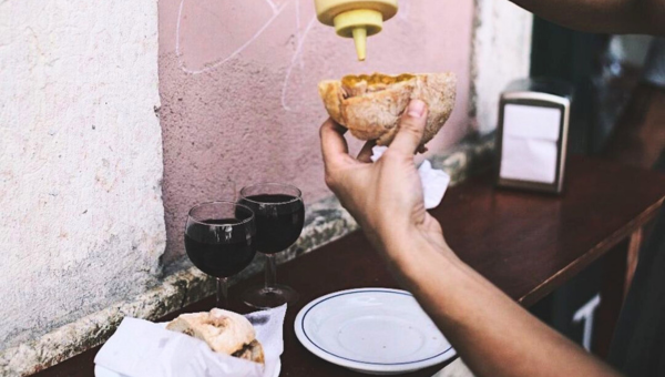 00.The 3 iconic Portuguese meat sandwiches_feat photo a man sitting at a table eating food