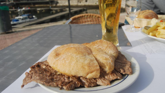 a sandwich sitting on top of a plate of food on a table