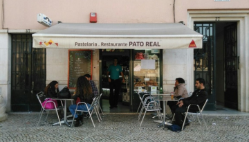 a group of people sitting in front of a store