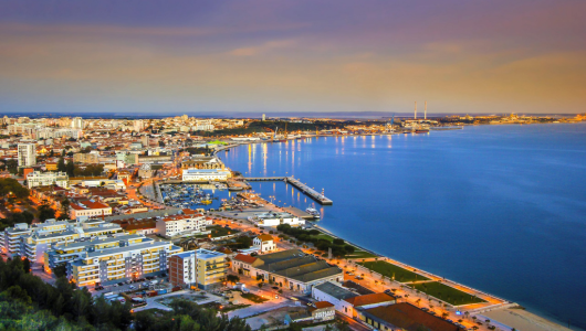 a large body of water with a city in the background