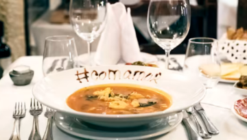 a plate of food and glasses of wine on a table