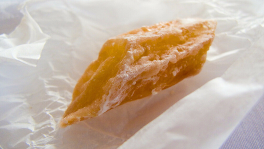 a half eaten doughnut sitting on top of a piece of paper