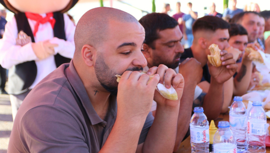 a group of people eating hot dogs