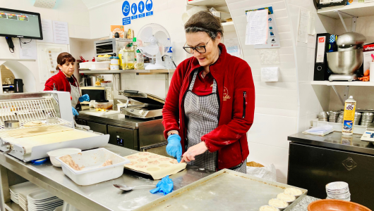 a person standing in a kitchen preparing food