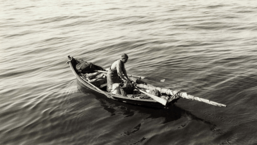 a man riding on the back of a boat in the water