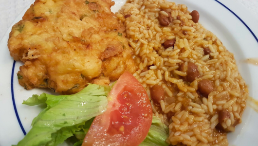 a close up of a plate of food with rice meat and vegetables