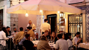 a group of people standing in front of a restaurant