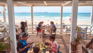 a group of people sitting at a beach