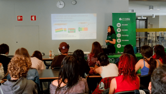 Person gives presentation to seated audience in classroom, with projection and ProVeg banner visible.