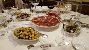 Table with plates of assorted appetizers and empty wine glasses