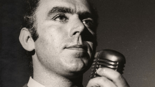 Man in suit holding vintage microphone, black and white photo