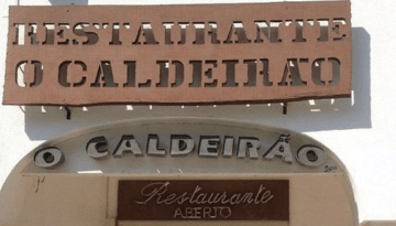 Exterior signage of Restaurante O Caldeirão with 'Aberto' indicating open.