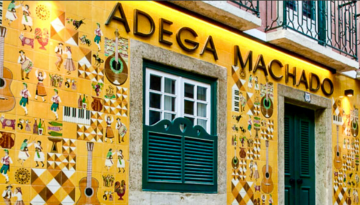 Facade of Adega Machado with colorful tiles depicting musical themes.