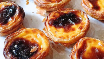 Portuguese custard tarts on a white surface, top view.