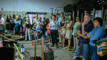 A group of people attentively listening to a presentation in an industrial setting.