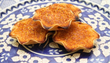 Three baked pastries on a blue floral plate.
