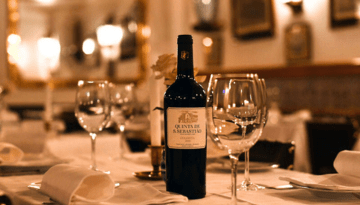 Wine bottle and glasses on a restaurant table set elegantly.