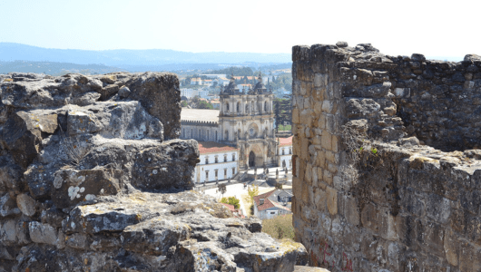 View of a historic abbey through ancient stone ruins.
