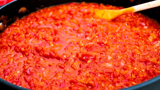 How the Portuguese changed the way the world eats - A pot of simmering red tomato sauce with a wooden spoon.