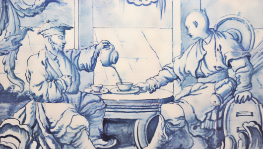 Blue and white illustration of two figures seated, one pouring liquid into a bowl.
