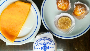 Various pastries on plates, including a slice of cake and small round sweets, one wrapped.