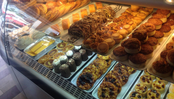 Bakery display case with assorted pastries and desserts.