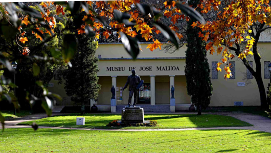 Entrance of Museu de Jose Malhoa with a statue and autumn leaves.