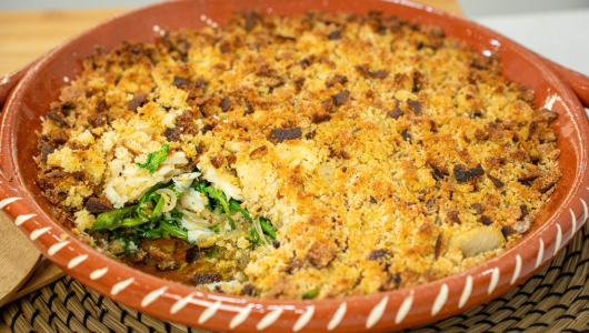Baked dish with breadcrumb topping and visible filling of greens and cheese in a ceramic dish.