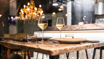 Elegant restaurant table set with wine glasses, plates, and water glasses.