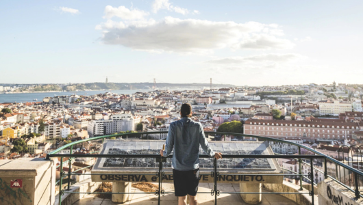 Person overlooking a cityscape from a high vantage point during the day.