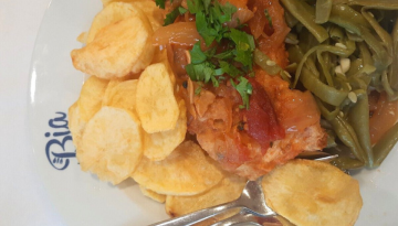Plate with sliced potatoes, meat with sauce, and green beans.