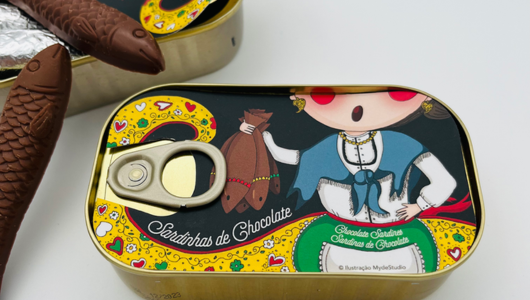 Chocolate sardines in open tin with colorful packaging showing a cartoon figure.