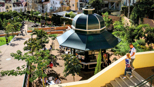 Park with a gazebo, people walking on stairs, and trees surrounding.