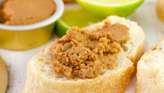 Bread slices with brown spread, lime wedges in background.