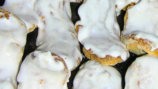 Cinnamon rolls topped with creamy white icing.