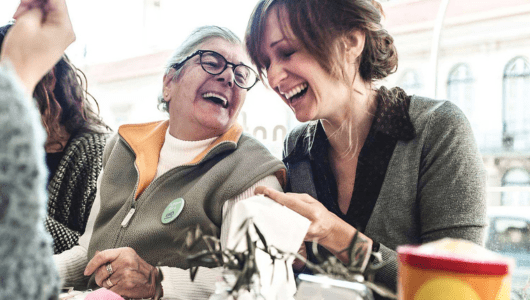 Two women laughing together at a table