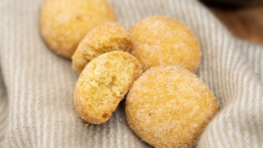 Close-up of sugar-coated cookies on striped cloth.
