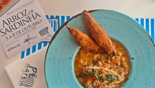 Plate of rice with sardines, next to a festival flyer and napkin.